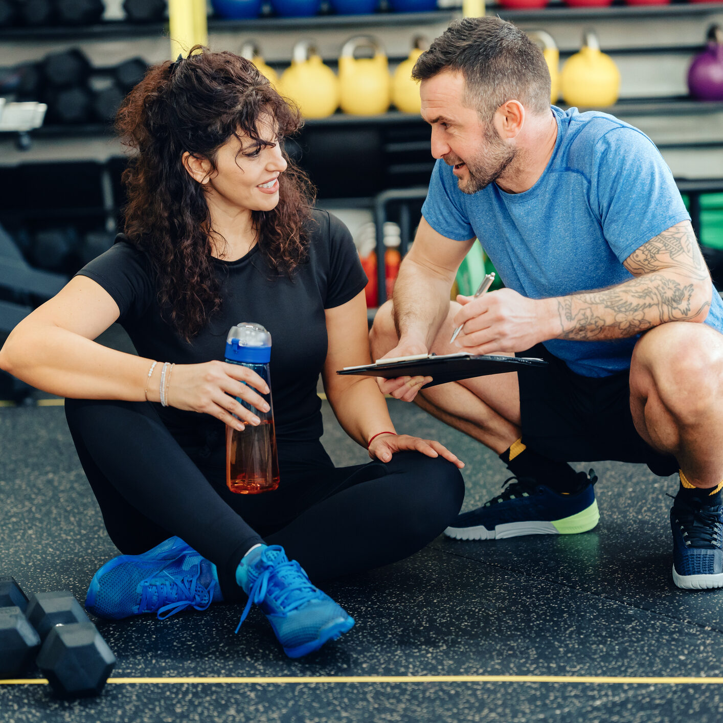 Personal trainer advising woman in gym